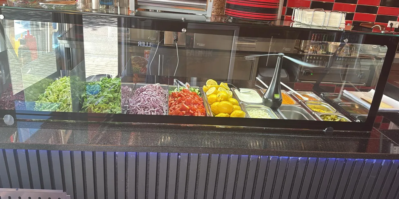Frisches Gemüse, Zwiebeln, Tomaten und Saucen an der Theke
